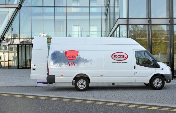 weißer Lieferwagen mit Logo und Icon von einem Rauchmelder