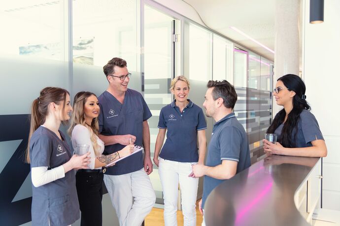 Zeigt das Team der Praxis vor der Rezeption