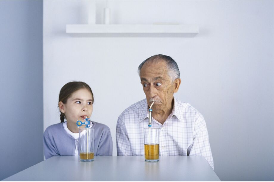 Frau und Mann trinken aus einem Glas mit Trinkhalm an dem Druchflusmessgeräte befestigt sind.