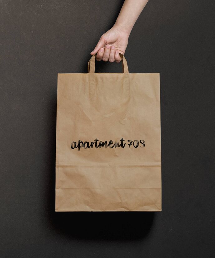 Hand hält Tragtasche mit Stempel der Wortmarke