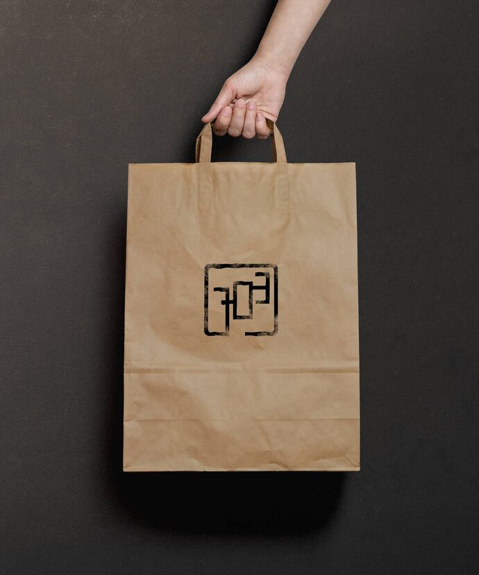 Hand hält Tragtasche mit Stempel der Bildmarke
