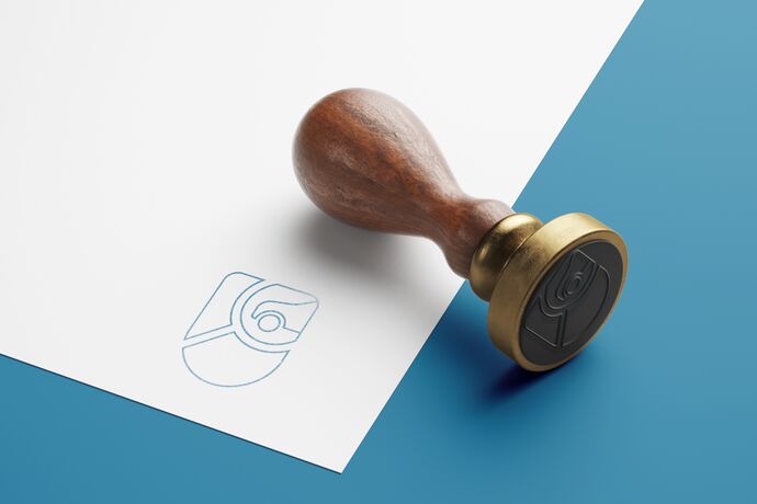 Blatt Papier mit Stempelaufdruck daneben liegt der Stempel
